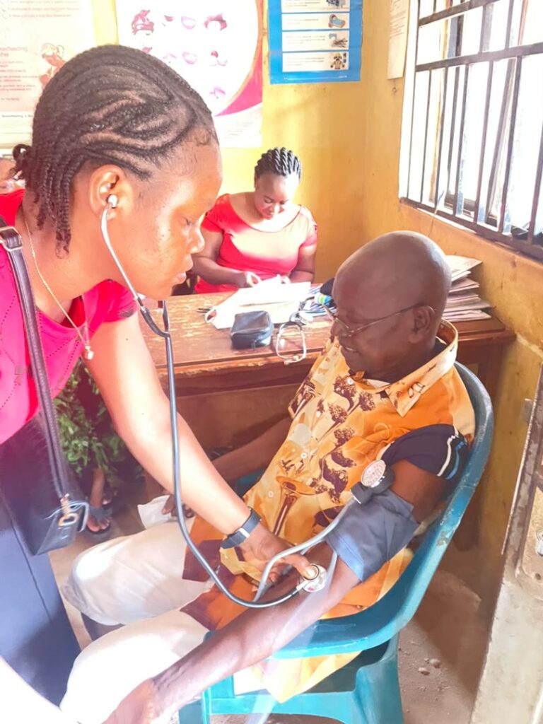 A healthcare worker checks an older community member’s blood pressure during the outreach.