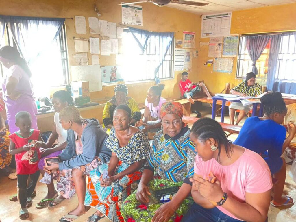 Community members and outreach workers share the health centre space during activities.